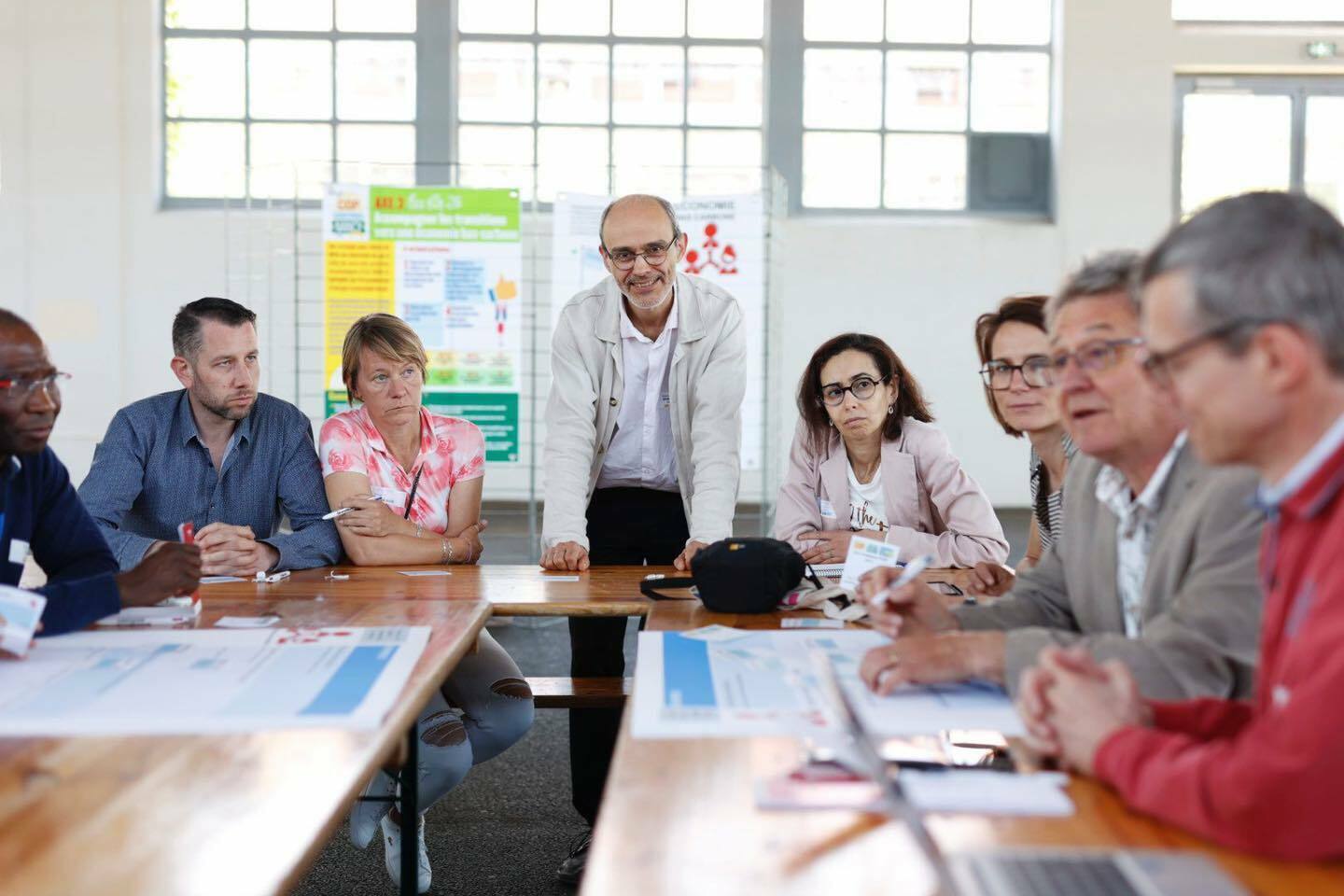 fr Un animateur de l'atelier est debout en face des participants assis 